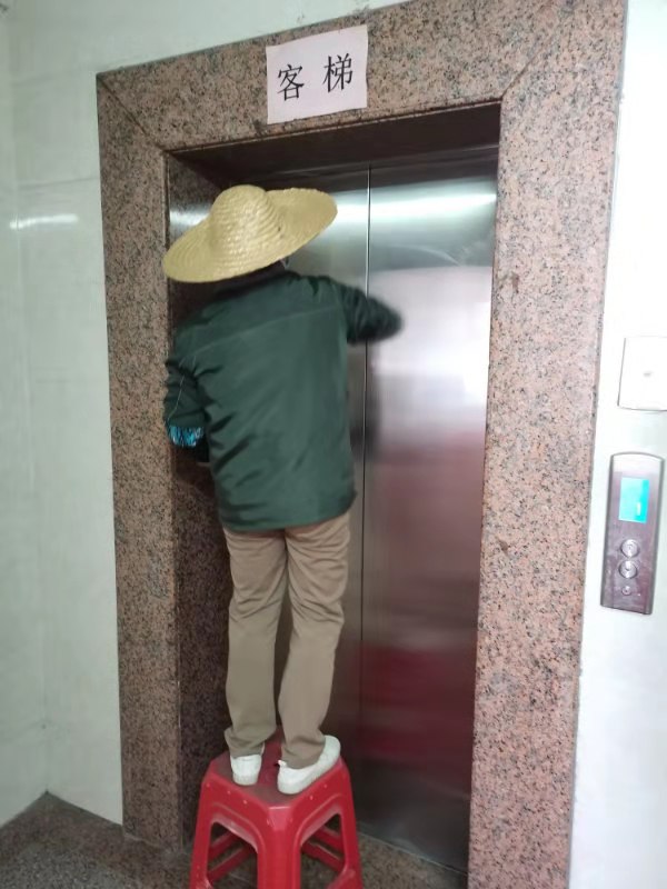 工作人员对电梯进行消毒